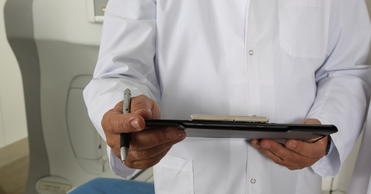 A doctor looking at a patient's chart to determine appropriate treatment for Alopecia Areata